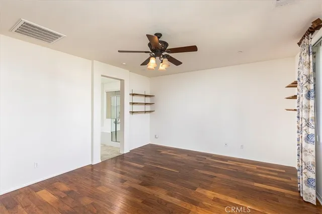 a view of a big room with wooden floor and a chandelier fan