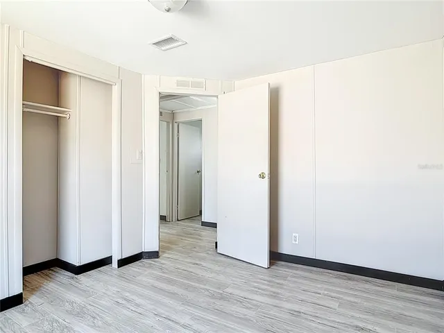 a view of an empty room with wooden floor