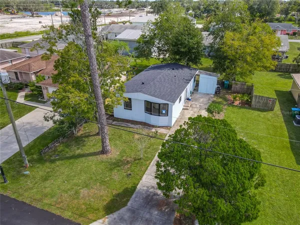 an aerial view of residential houses with outdoor space and trees