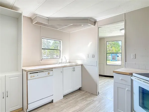 a view of cabinets a kitchen island wooden floor and a window