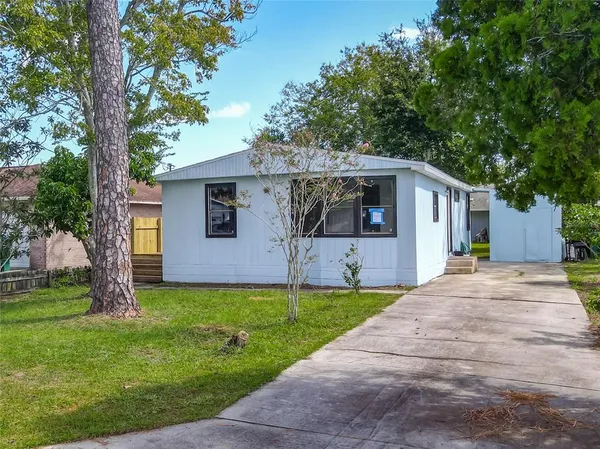 a front view of a house with yard and tree