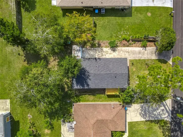 an aerial view of a house with a yard lake house next to yard and green space