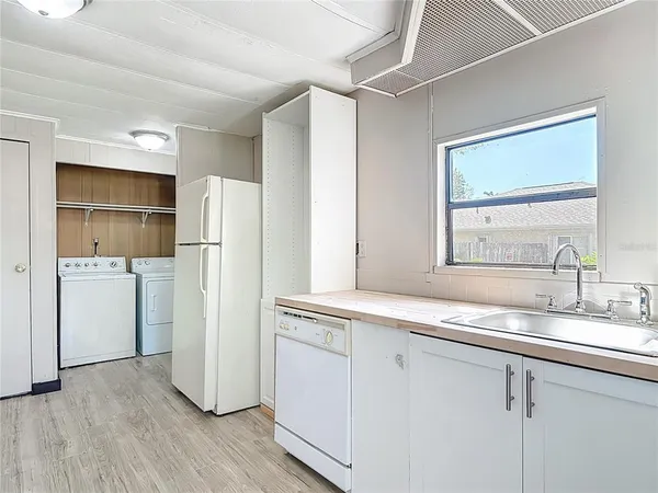 a kitchen with a refrigerator sink and cabinets