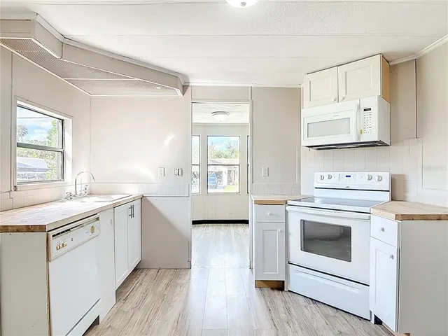 a kitchen with a stove a sink and wooden floor