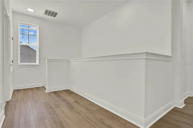 a view of an empty room with wooden floor