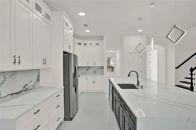 a kitchen with white cabinets and refrigerator