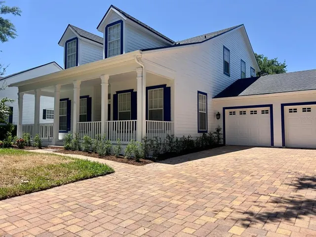 a front view of a house with a yard and potted plants