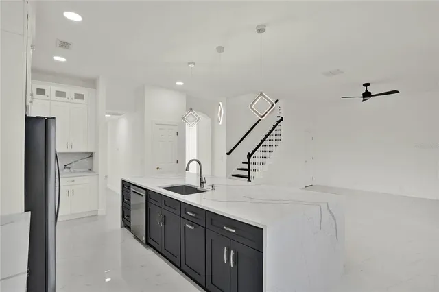 a kitchen with stainless steel appliances a sink and a refrigerator