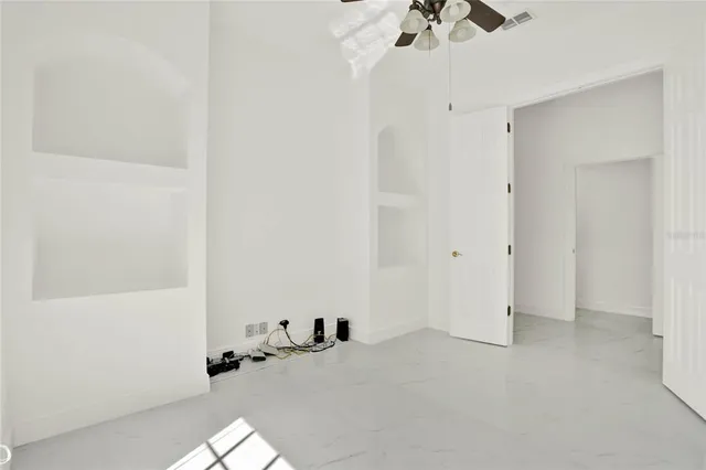 a view of a room with a chandelier fan