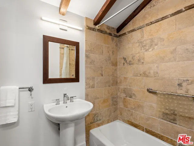 a bathroom with a sink mirror and shower