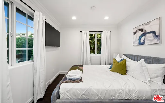 a bedroom with a bed and a flat screen tv