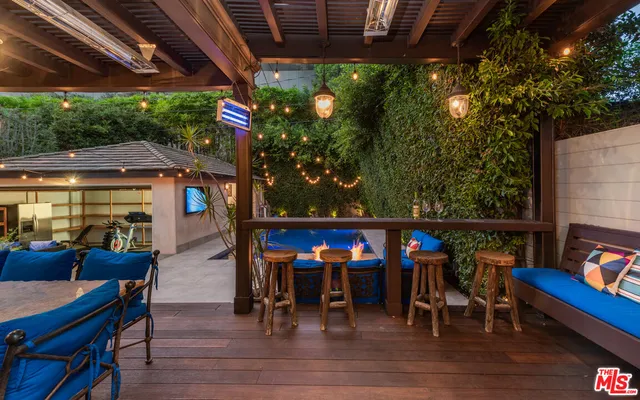 a view of a chairs and table in a patio next to a yard