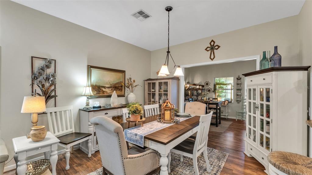 728 Canberra Road Winter Haven, FL 33884 - Photo 12 of 47 a view of a dining room and livingroom with furniture wooden floor a chandelier
