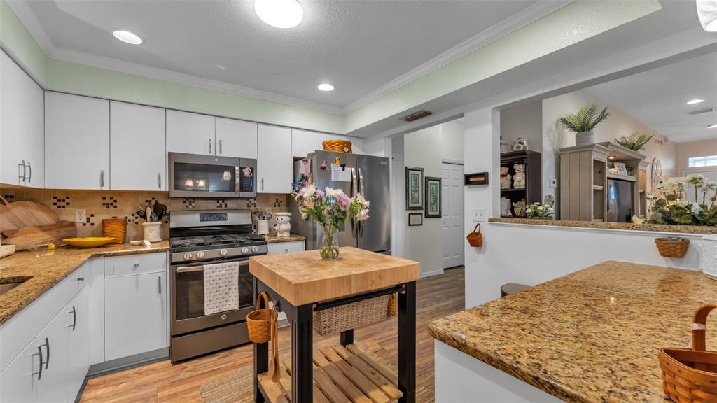 728 Canberra Road Winter Haven, FL 33884 - Photo 15 of 47 a kitchen with granite countertop a sink stove and refrigerator
