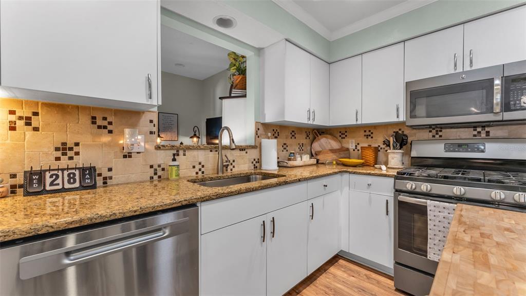 728 Canberra Road Winter Haven, FL 33884 - Photo 17 of 47 a kitchen with stainless steel appliances granite countertop a sink stove and cabinets