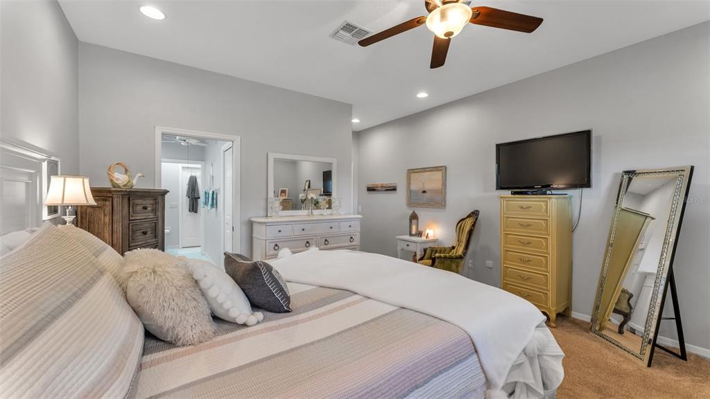 728 Canberra Road Winter Haven, FL 33884 - Photo 26 of 47 a bedroom with a bed a flat screen tv and a chandelier