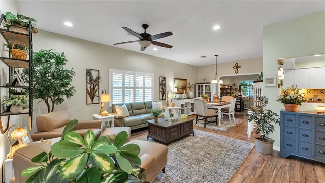 a living room with furniture ceiling fan and a large window