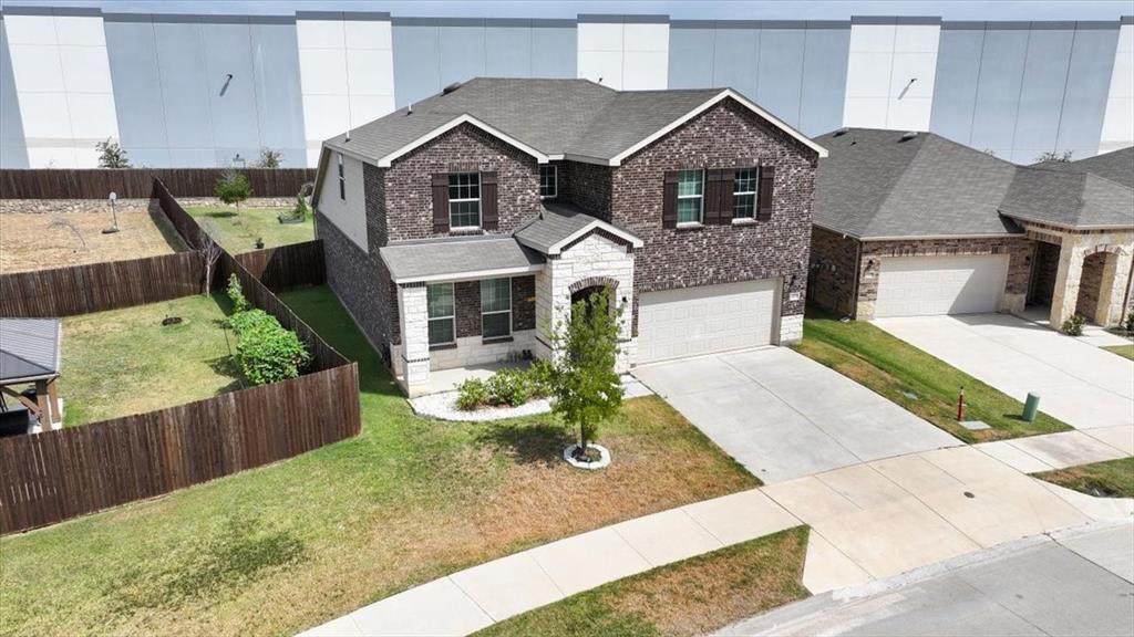 1201 Timberhurst Trail Fort Worth, TX 76131 - Photo 35 of 40 Two-story residence featuring a brick and stone facade, attached two-car garage, and a fenced backyard