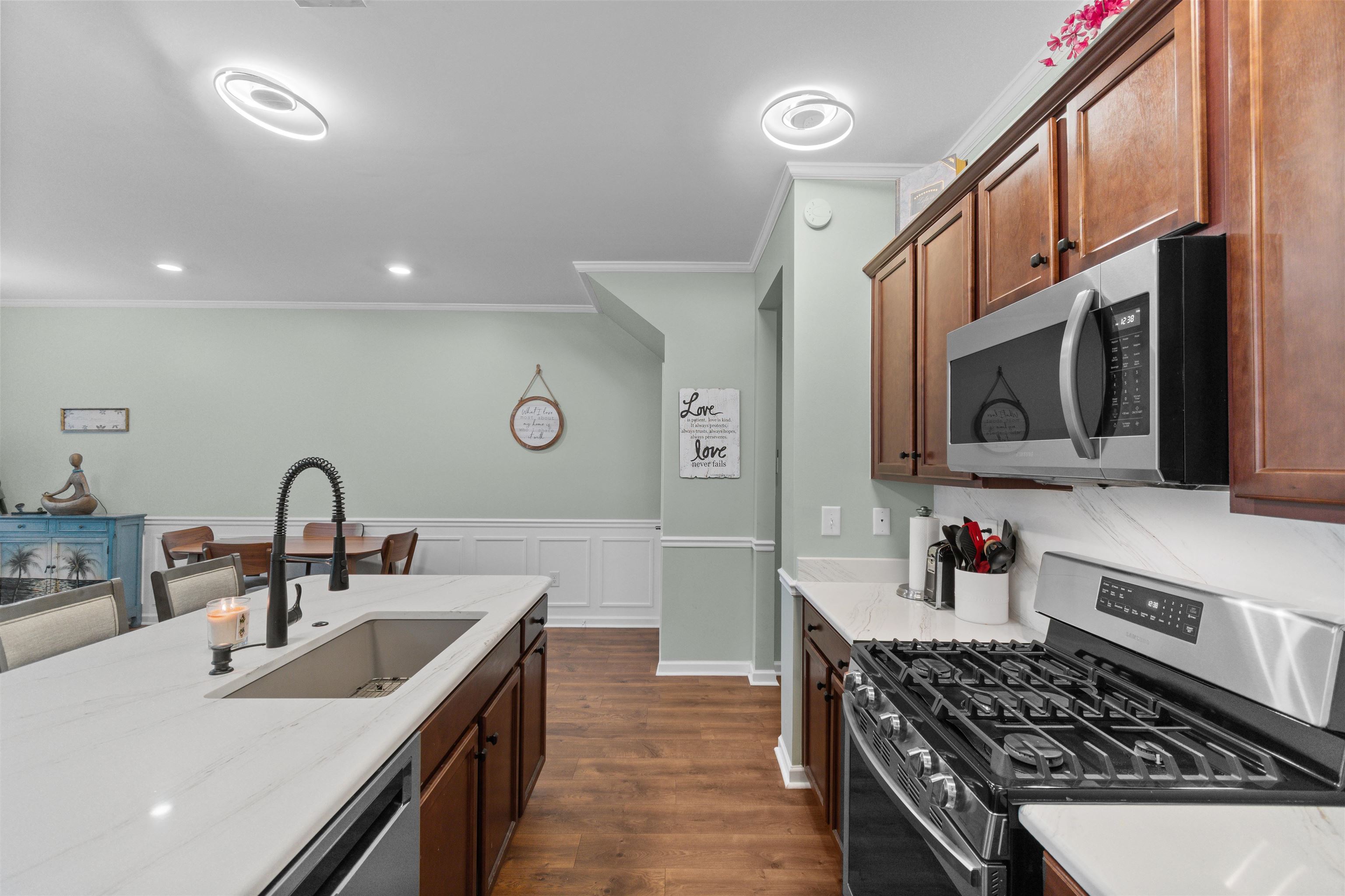 2408 Heritage Loop, Unit 2408 Myrtle Beach, SC 29577 - Photo 3 of 40 Kitchen featuring appliances with stainless steel finishes, light stone counters, dark wood-style flooring, ornamental molding, and wainscoting