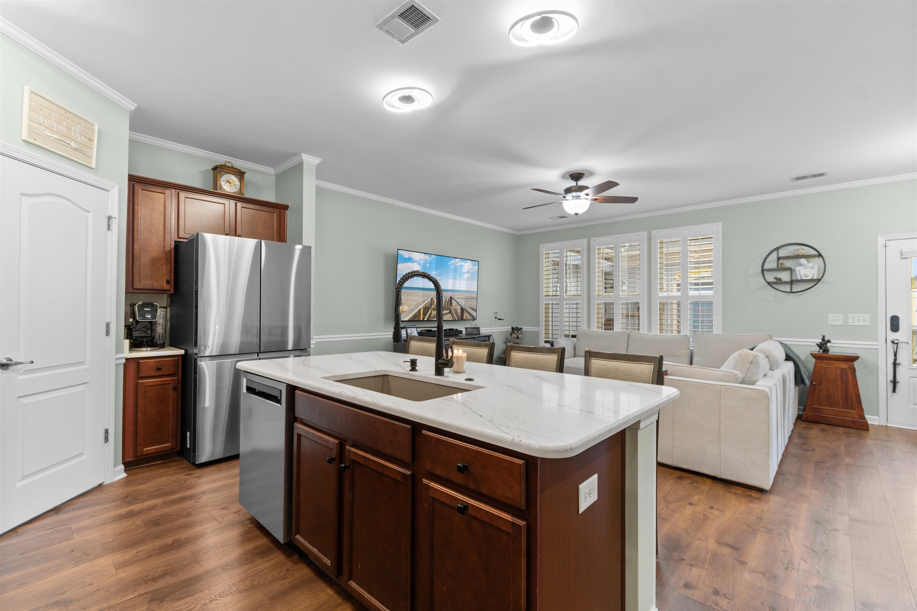 2408 Heritage Loop, Unit 2408 Myrtle Beach, SC 29577 - Photo 39 of 40 Kitchen featuring open floor plan, appliances with stainless steel finishes, a kitchen island with sink, dark wood-type flooring, and ornamental molding