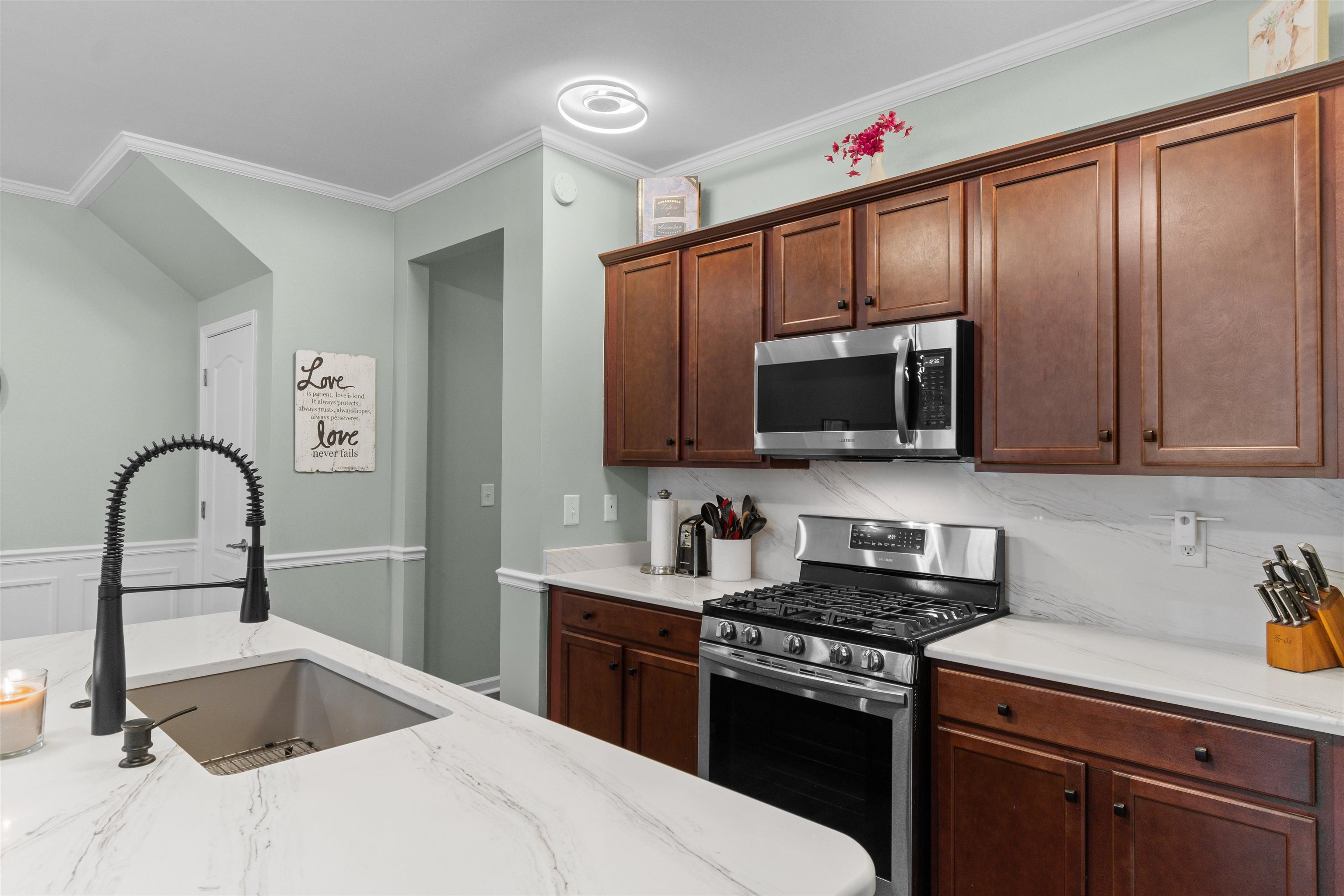 2408 Heritage Loop, Unit 2408 Myrtle Beach, SC 29577 - Photo 5 of 40 Kitchen featuring appliances with stainless steel finishes, crown molding, and light stone counters