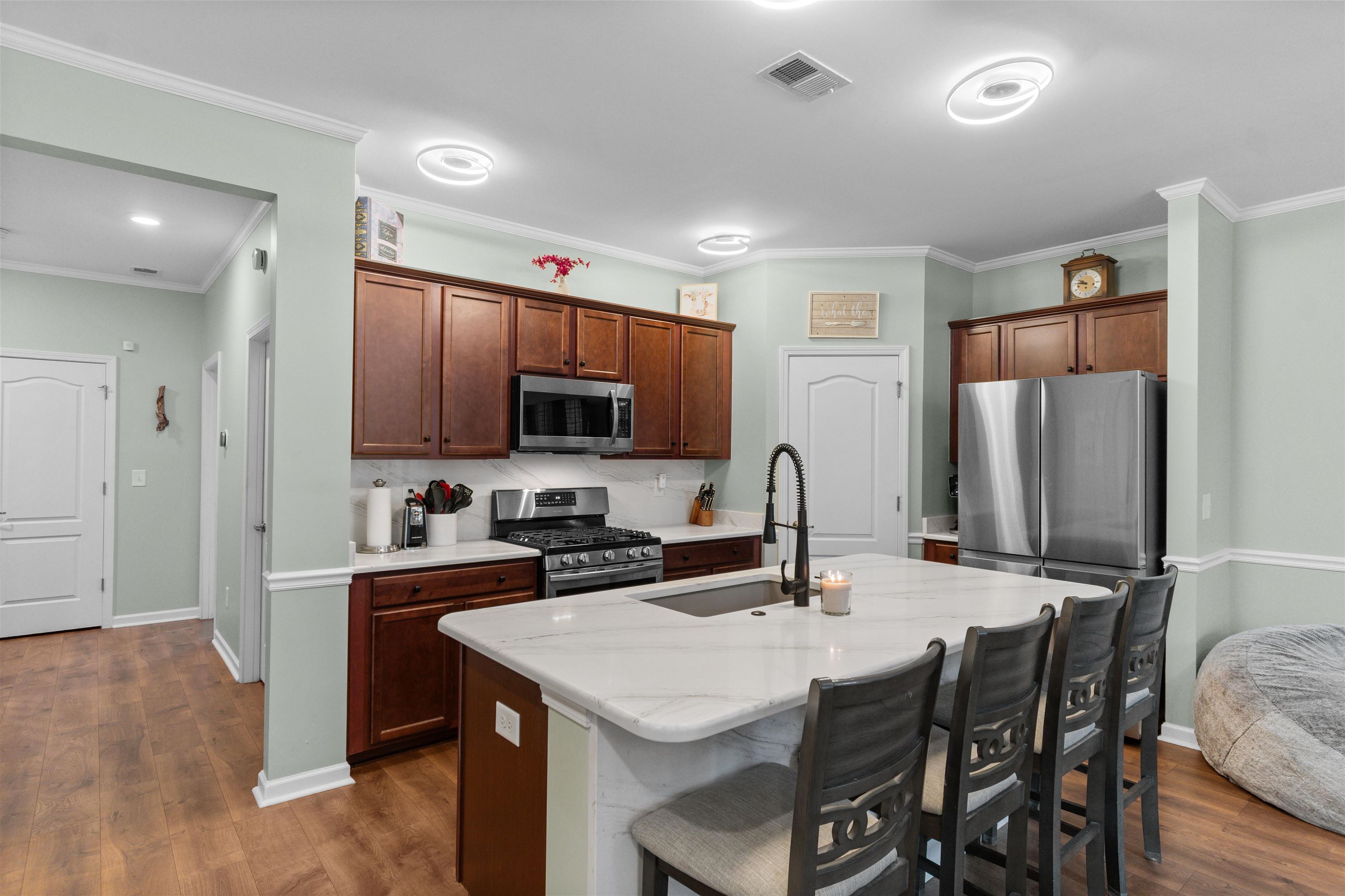 2408 Heritage Loop, Unit 2408 Myrtle Beach, SC 29577 - Photo 6 of 40 Kitchen with appliances with stainless steel finishes, a breakfast bar, an island with sink, light stone countertops, and dark wood-style floors