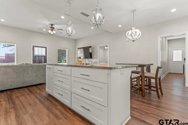 a spacious bathroom with a granite countertop sink a mirror and vanity