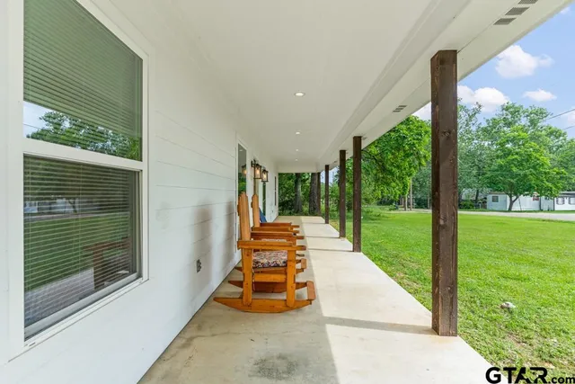 a balcony with chairs and a yard