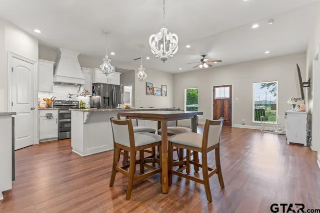 a kitchen with stainless steel appliances kitchen island granite countertop a table and chairs in it