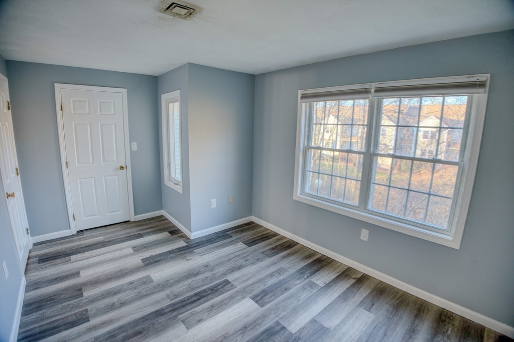 43 Patrick Road, Unit 43 Tewksbury, MA 01876 - Photo 24 of 27 wooden floor in an empty room with a window