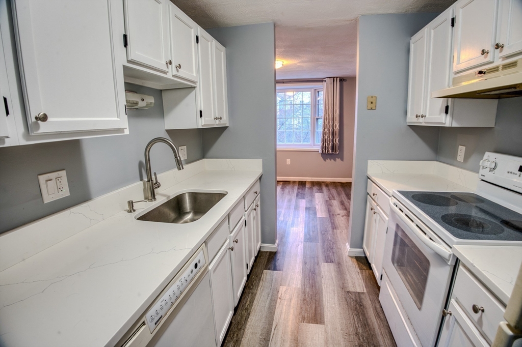 43 Patrick Road, Unit 43 Tewksbury, MA 01876 - Photo 8 of 27 a kitchen with a sink a stove and cabinets