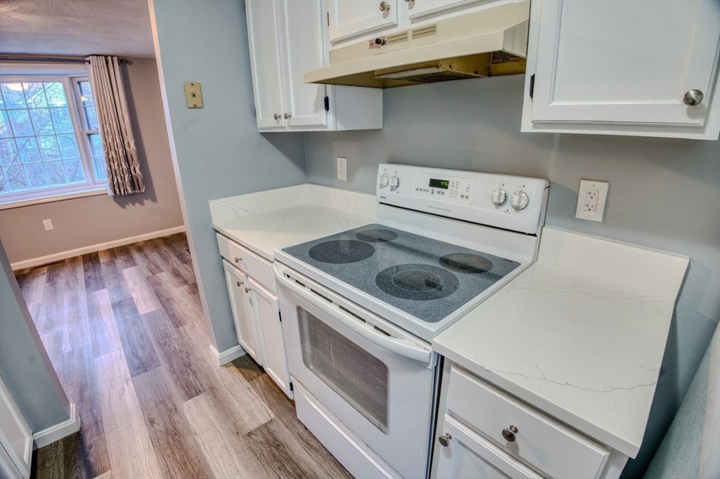43 Patrick Road, Unit 43 Tewksbury, MA 01876 - Photo 10 of 27 a kitchen with a stove white cabinets and a sink