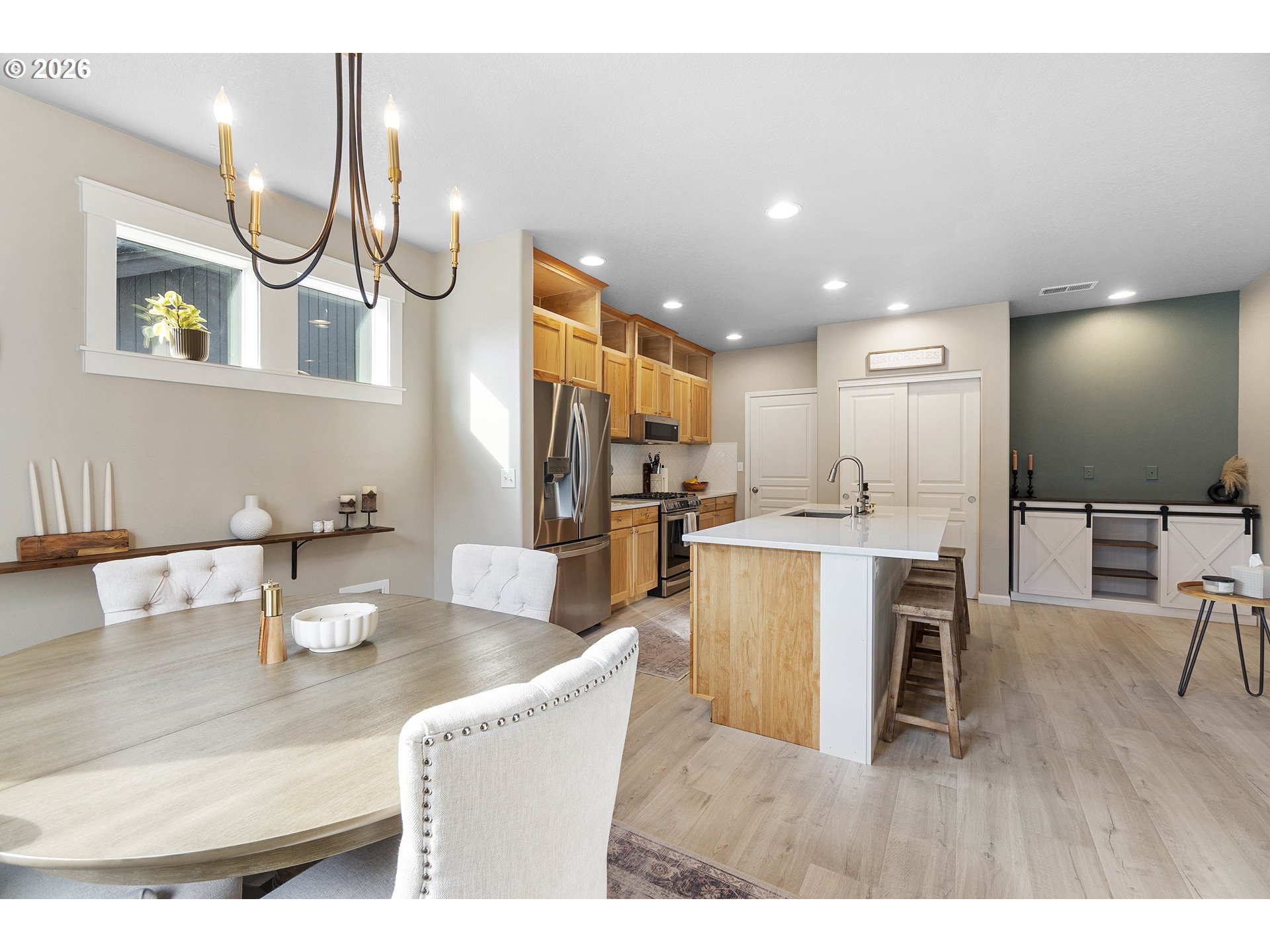 15520 Rainier Avenue Sandy, OR 97055 - Photo 16 of 38 a kitchen with stainless steel appliances granite countertop a refrigerator a microwave a stove and white cabinets with wooden floor