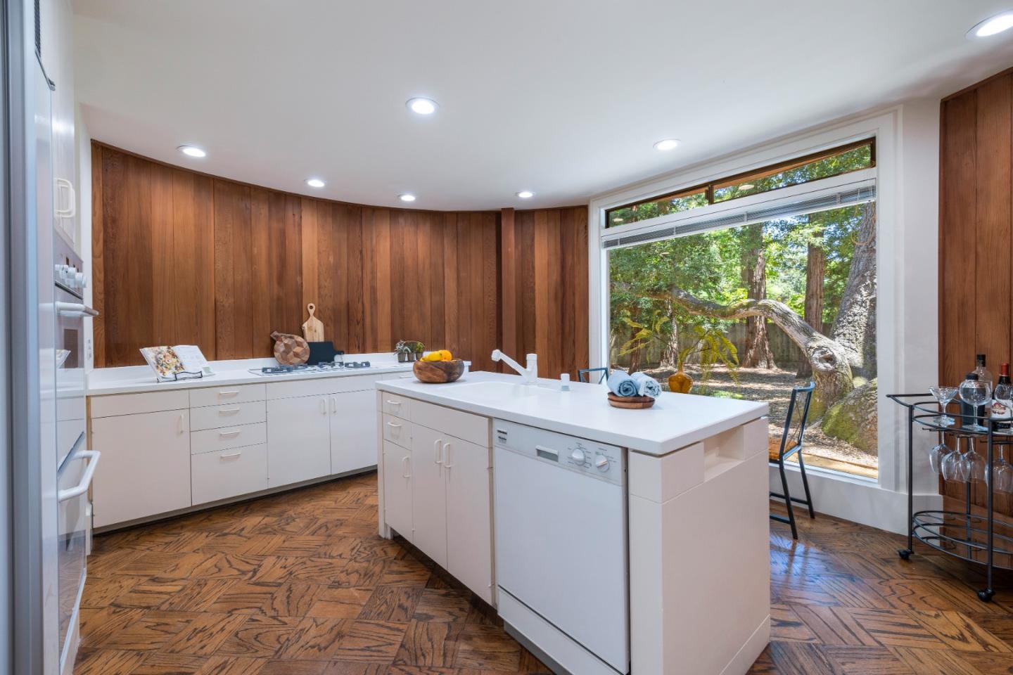 3364 Woodside Road Woodside, CA 94062 - Photo 20 of 48 a kitchen with a sink stove and white cabinets with wooden floor