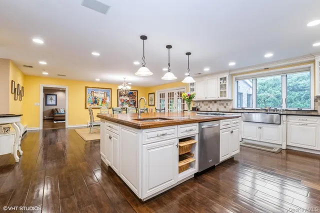 a kitchen with stainless steel appliances granite countertop wooden floors and white cabinets