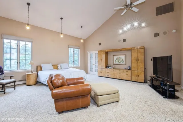 a spacious bedroom with a bed window and couch