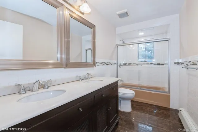 a bathroom with a sink a toilet a shower and a mirror