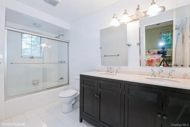 a bathroom with a double vanity sink mirror and toilet