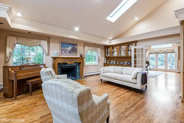 a living room with furniture a fireplace and a large window