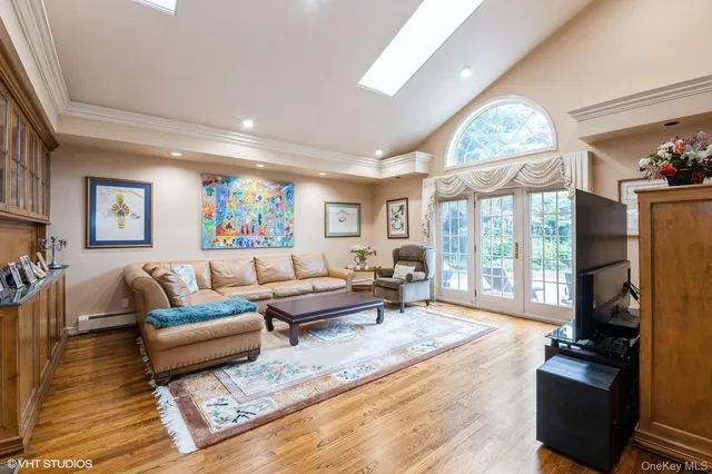 a living room with furniture large window and wooden floor