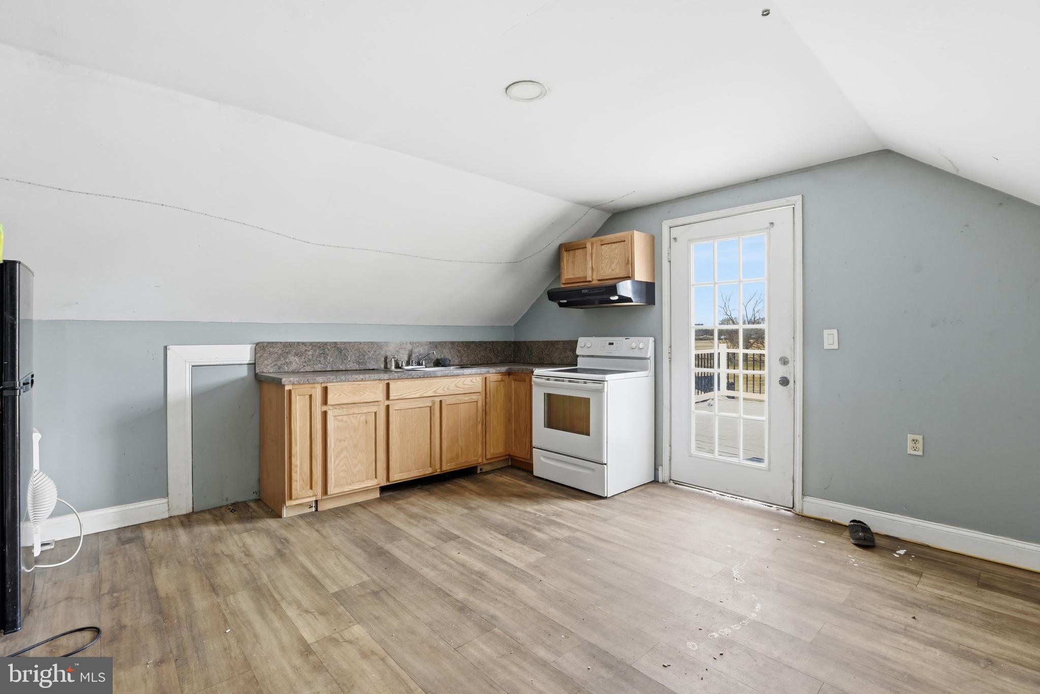 20915 Dover Bridge Road Preston, MD 21655 - Photo 45 of 60 a kitchen with stainless steel appliances a white stove top oven cabinets and a wooden floor