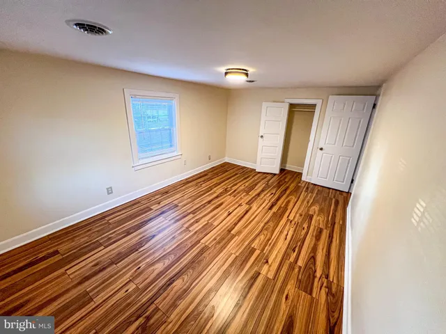 a view of an empty room with wooden floor