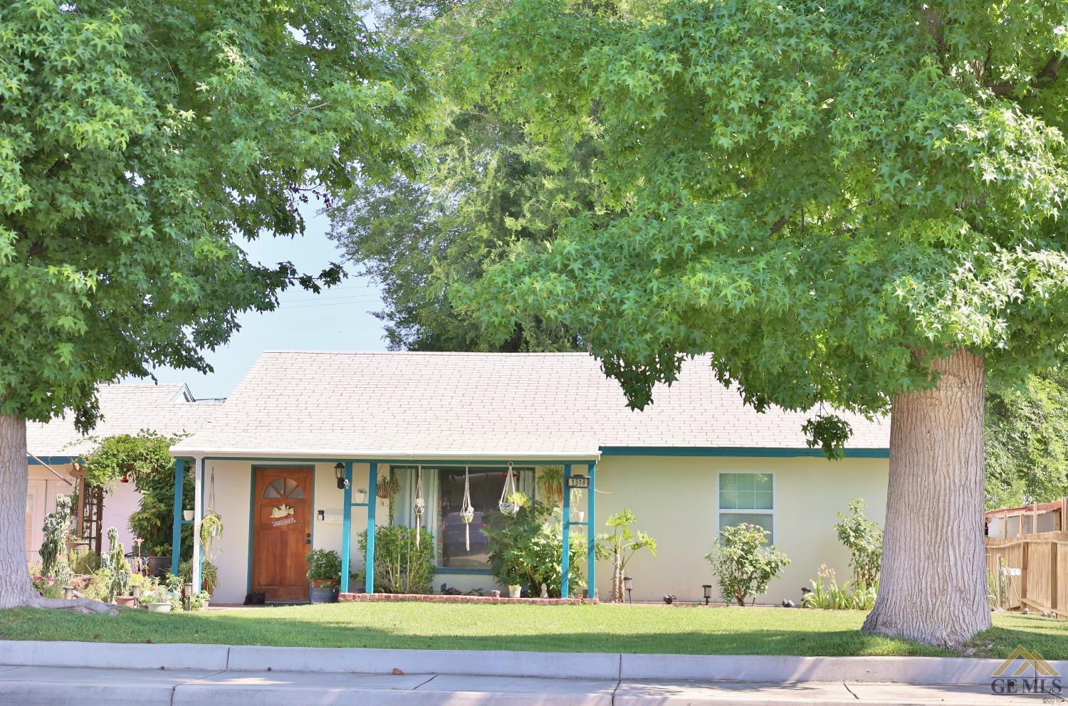 Undisclosed Address Wasco, CA 93280 - Photo 3 of 40 a view of a white house with a plants and large tree