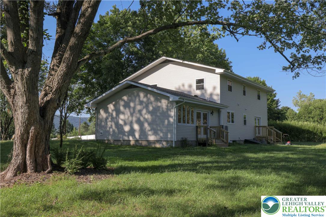 919 Point Phillips Road Bath, PA 18014 - Photo 50 of 59 A well-maintained side exterior offers expansive views of a verdant lawn and distant rolling hills.