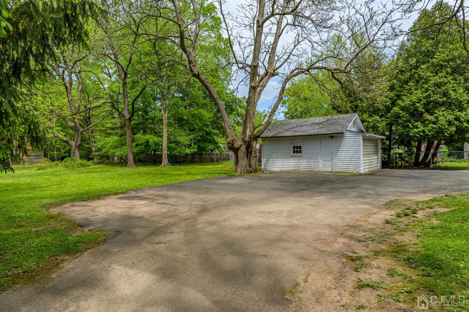 1237 Lower Ferry Road Ewing, NJ 08618 - Photo 28 of 42 a backyard of a house with large trees and brick walls