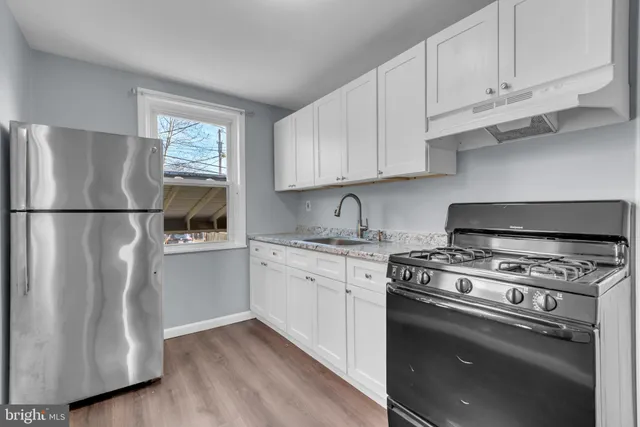 a kitchen with cabinets appliances and a wooden floor