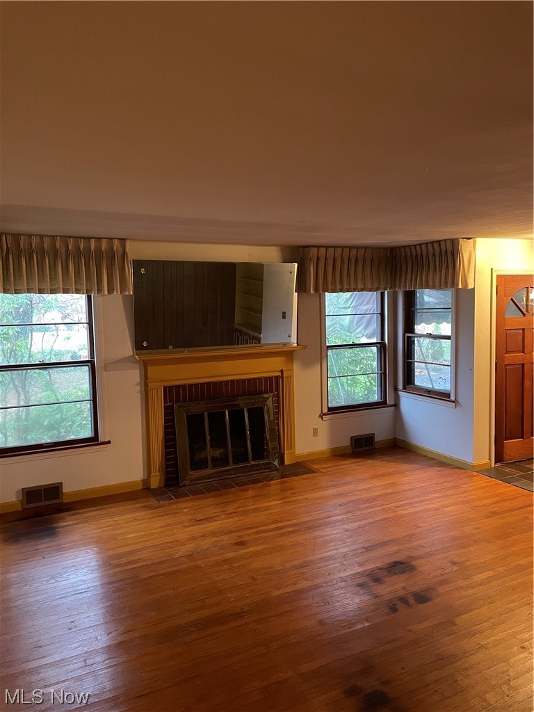 4018 Dover Road Youngstown, OH 44511 - Photo 9 of 31 Unfurnished living room with dark hardwood / wood-style floors, a wealth of natural light, and a brick fireplace