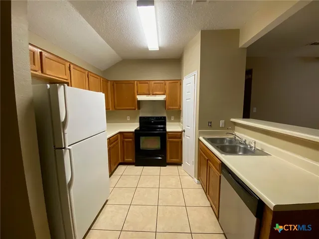a kitchen with a refrigerator a stove a sink and a refrigerator