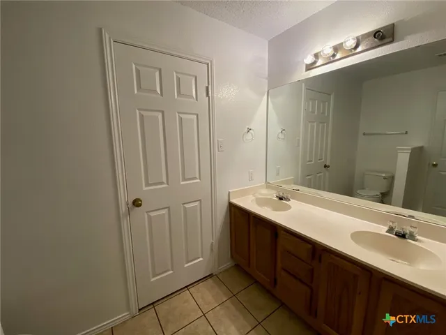 a bathroom with a double vanity sink and a mirror