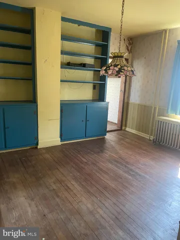 a view of empty room with a fireplace and wooden floor